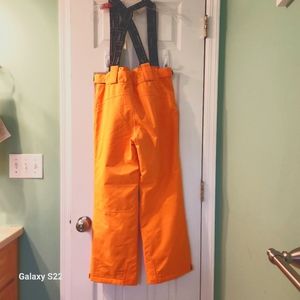 Kids size 12 karbon snow pants with suspenders, bright orange